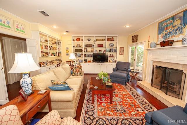 living room featuring ornamental molding, a fireplace, and hardwood / wood-style floors