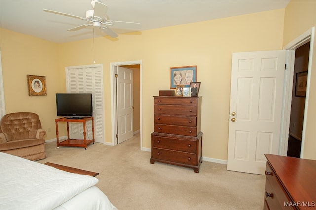 bedroom with light carpet, ceiling fan, and a closet