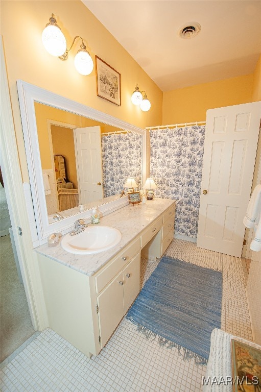 bathroom featuring walk in shower, vanity, and tile patterned floors