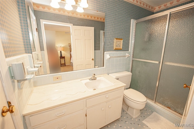 bathroom featuring a shower with door, vanity, and toilet