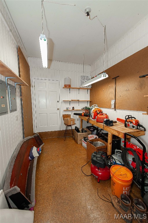 interior space featuring wooden walls, a workshop area, and electric panel