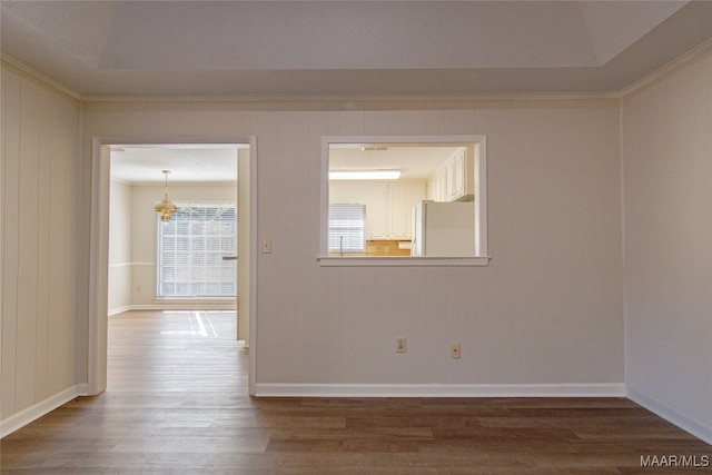 unfurnished room with wood-type flooring, crown molding, and wooden walls