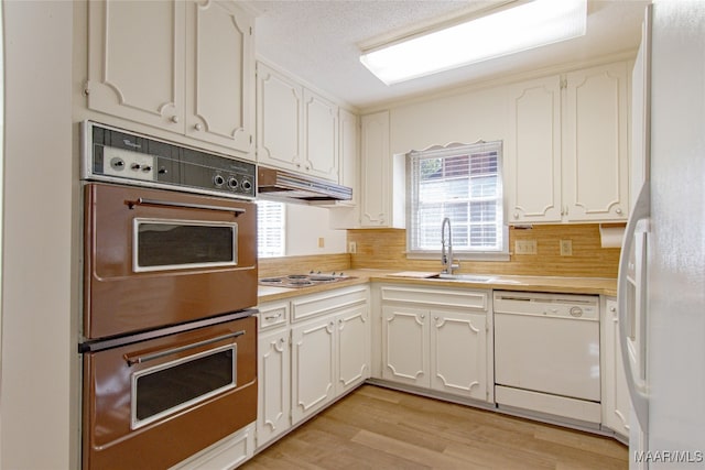 kitchen with decorative backsplash, light hardwood / wood-style flooring, white cabinets, and white appliances