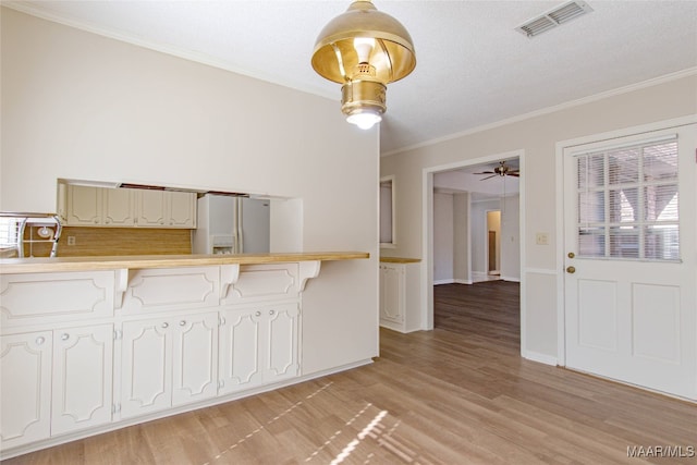 kitchen featuring kitchen peninsula, ceiling fan, light wood-type flooring, white fridge with ice dispenser, and white cabinetry