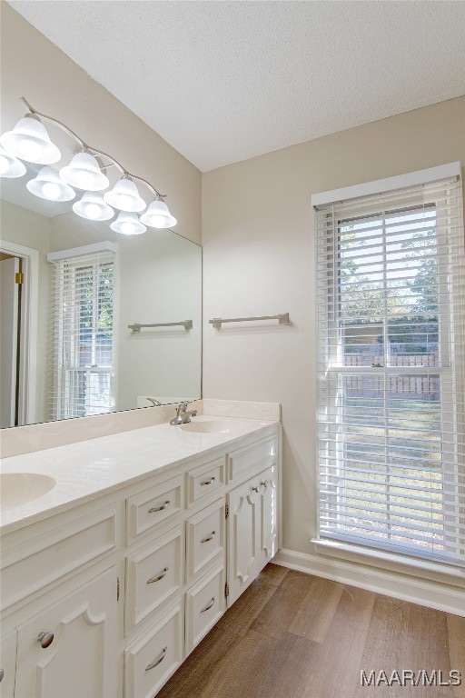 bathroom with hardwood / wood-style flooring, vanity, and a textured ceiling