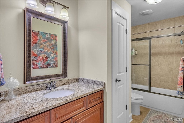 full bathroom with vanity, toilet, tile patterned floors, and bath / shower combo with glass door