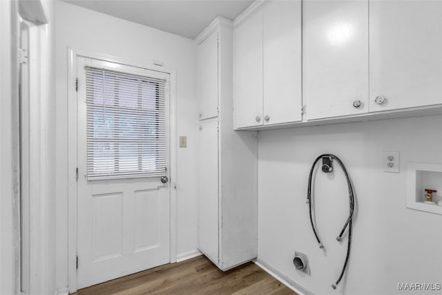 washroom featuring hookup for a washing machine, cabinets, and light hardwood / wood-style flooring