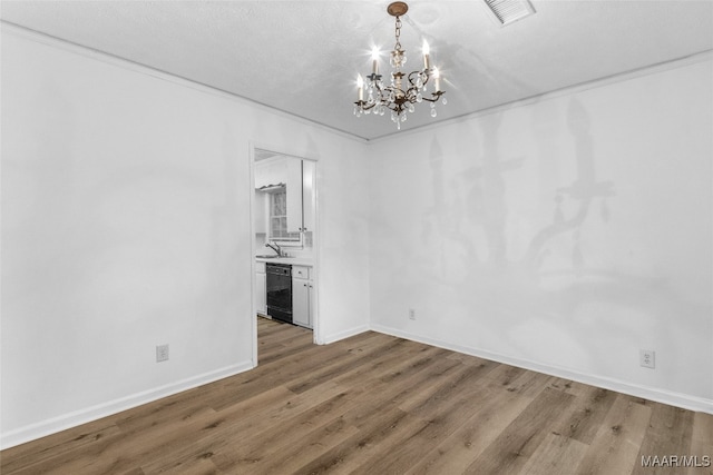 interior space with a notable chandelier, sink, hardwood / wood-style floors, and a textured ceiling