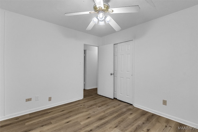 unfurnished bedroom featuring ceiling fan, a closet, and hardwood / wood-style floors