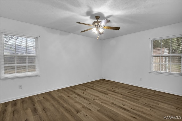 unfurnished room with a textured ceiling, dark hardwood / wood-style flooring, and ceiling fan