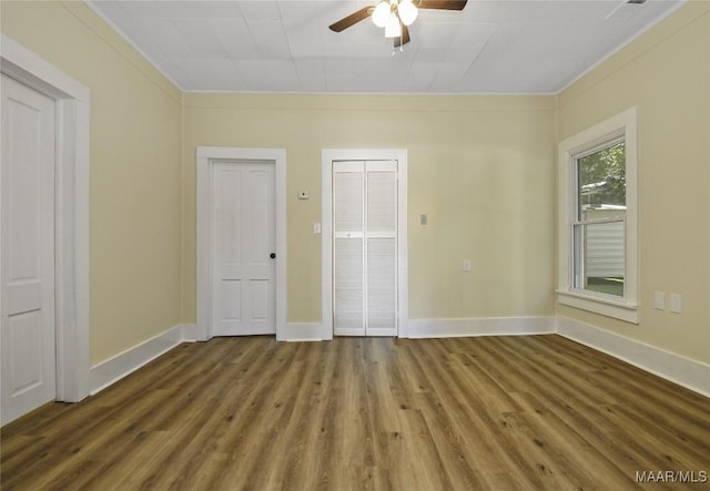 empty room with baseboards, wood finished floors, and a ceiling fan