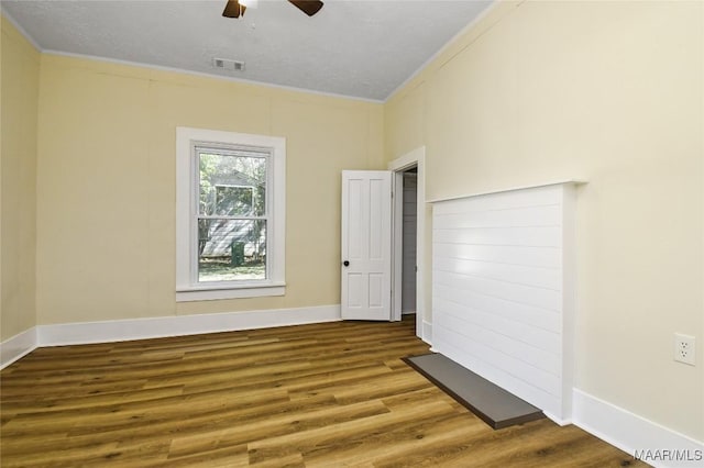unfurnished room featuring baseboards, ceiling fan, visible vents, and wood finished floors