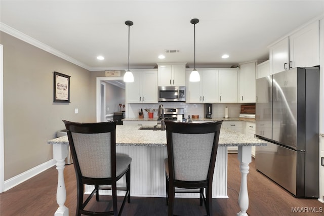 kitchen with light stone counters, dark wood-type flooring, white cabinetry, hanging light fixtures, and appliances with stainless steel finishes