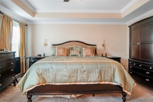 carpeted bedroom with crown molding, a tray ceiling, and ceiling fan