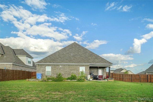 rear view of property featuring a yard and a patio area