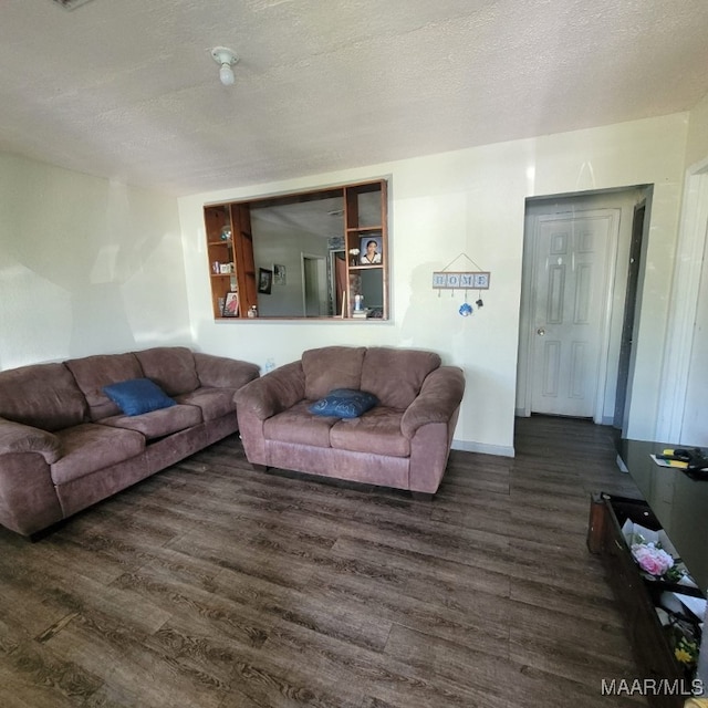 living room featuring a textured ceiling and dark hardwood / wood-style flooring