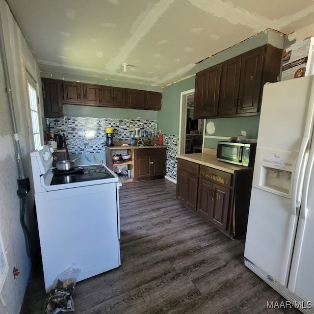 kitchen featuring white appliances, dark brown cabinets, dark wood-type flooring, and tasteful backsplash