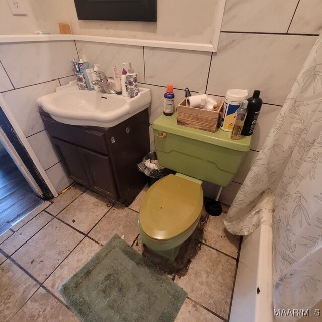 full bathroom with vanity, tile patterned floors, tile walls, toilet, and shower / tub combo with curtain