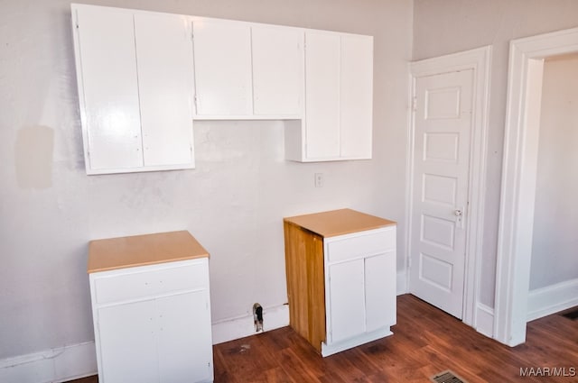 kitchen featuring white cabinetry and dark hardwood / wood-style flooring