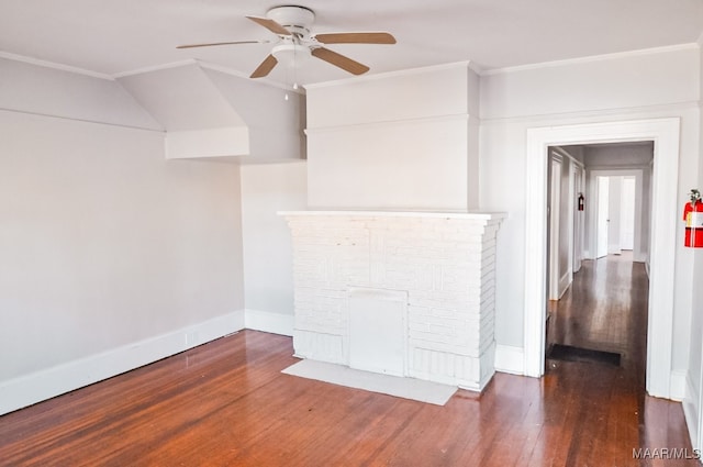 unfurnished living room featuring dark hardwood / wood-style flooring, lofted ceiling, a fireplace, crown molding, and ceiling fan