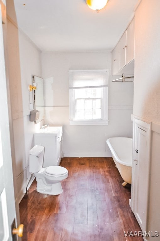 bathroom featuring a tub to relax in, hardwood / wood-style floors, vanity, and toilet