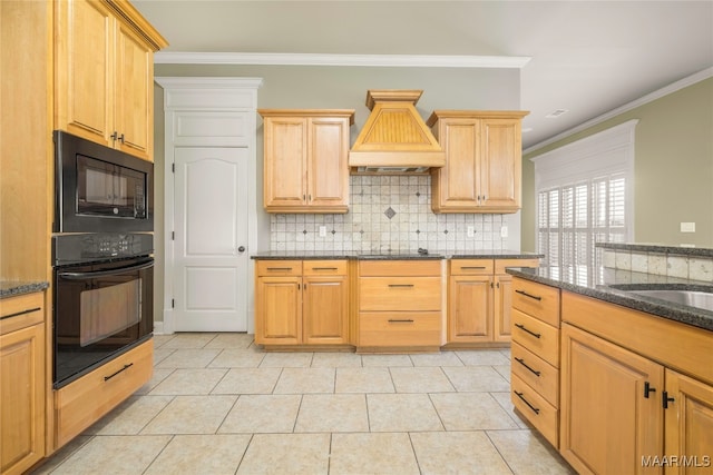 kitchen with dark stone counters, black appliances, light tile patterned floors, and crown molding