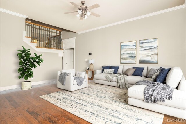 living room featuring wood-type flooring, crown molding, and ceiling fan