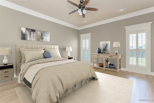 bedroom featuring ceiling fan, light wood-type flooring, and crown molding