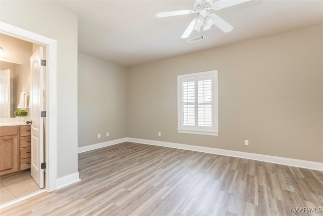 empty room with ceiling fan and light hardwood / wood-style flooring