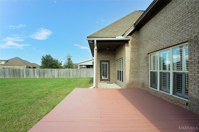 wooden deck featuring a lawn and a patio