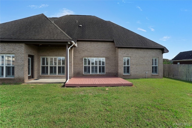 back of house featuring a deck and a lawn