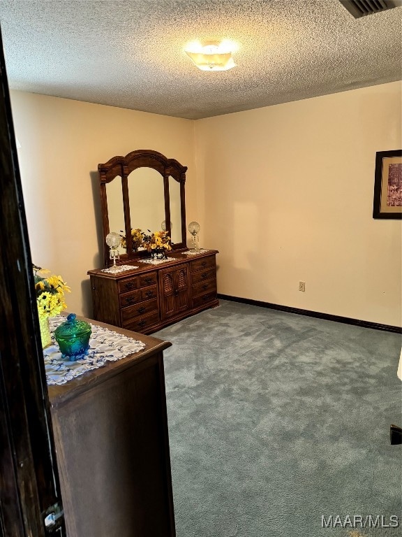 bedroom with a textured ceiling and carpet flooring