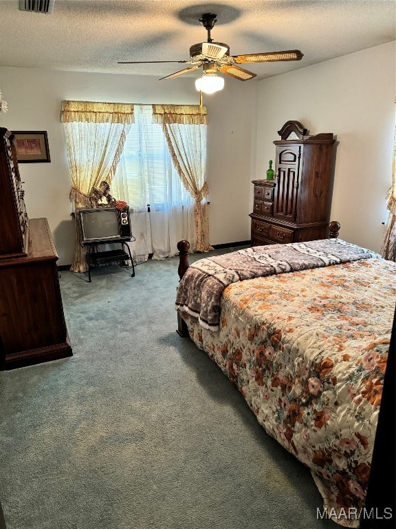 bedroom with carpet, ceiling fan, and a textured ceiling