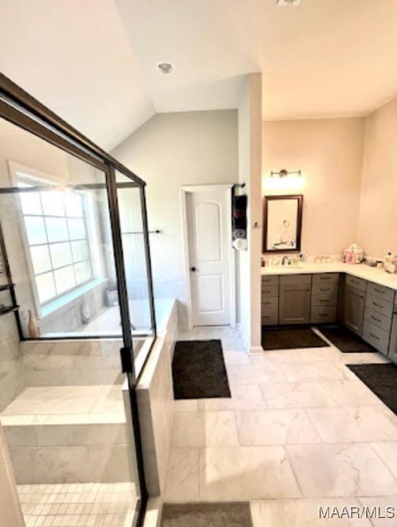 bathroom with vanity, a shower with door, marble look tiles, and lofted ceiling