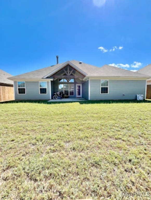 rear view of house featuring a yard