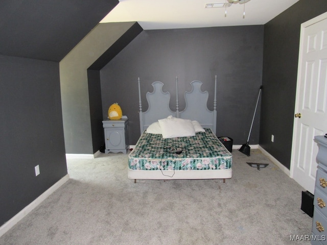 unfurnished bedroom featuring light carpet and lofted ceiling