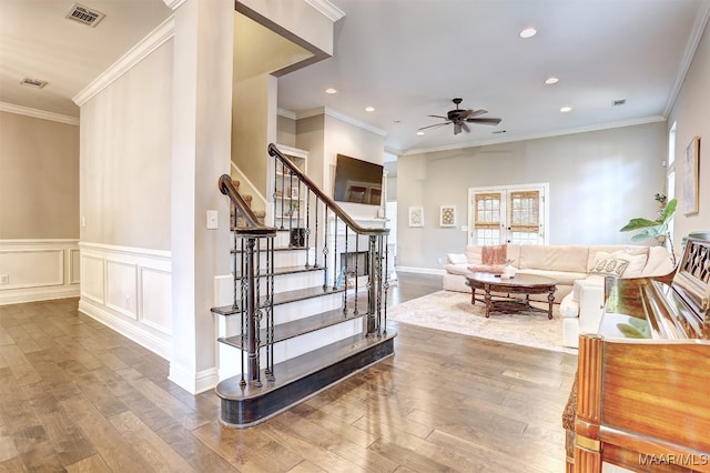 stairway featuring wood-type flooring, ornamental molding, and ceiling fan