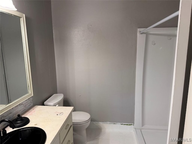 bathroom featuring vanity, a shower, and toilet