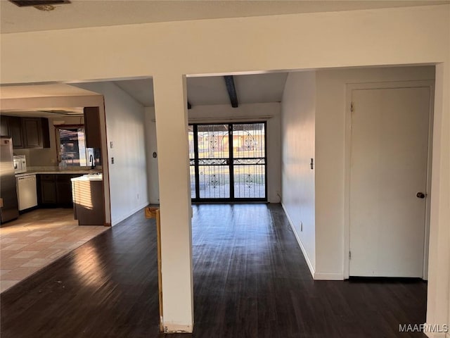 unfurnished living room featuring beamed ceiling and dark wood-type flooring