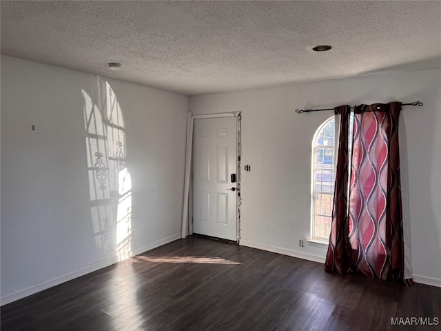 entrance foyer with dark wood-type flooring and a textured ceiling