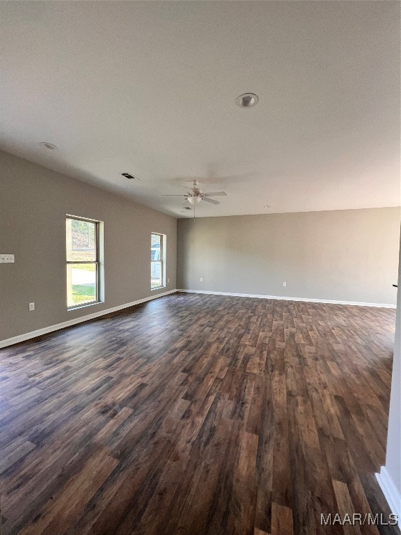 empty room with ceiling fan and dark hardwood / wood-style flooring