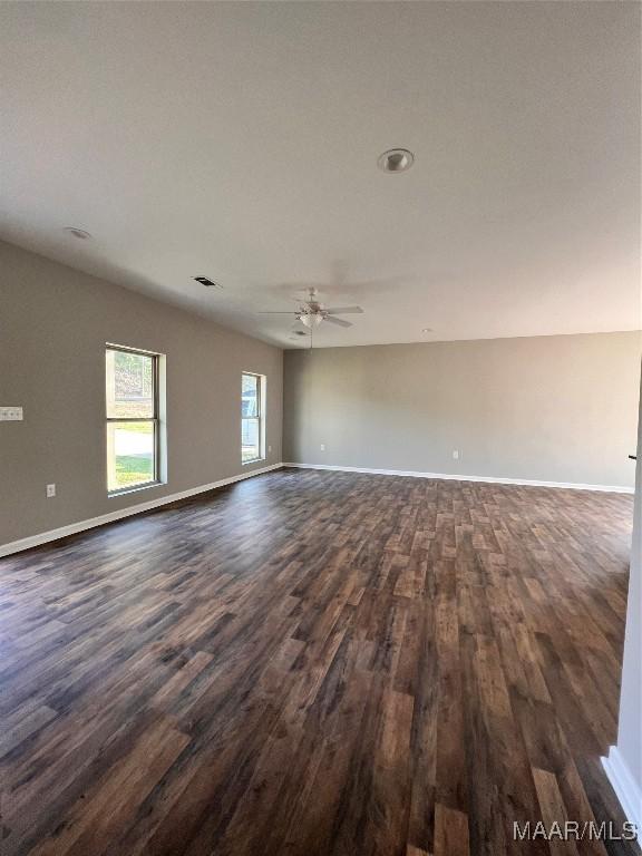 551 Butter And Egg Rd, Troy, AL 36081 - empty room with dark wood finished floors, ceiling fan, and baseboards