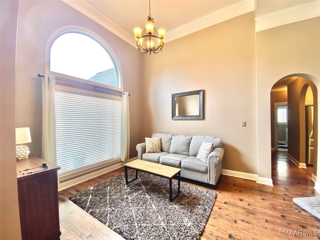 living room with crown molding, a notable chandelier, and wood-type flooring