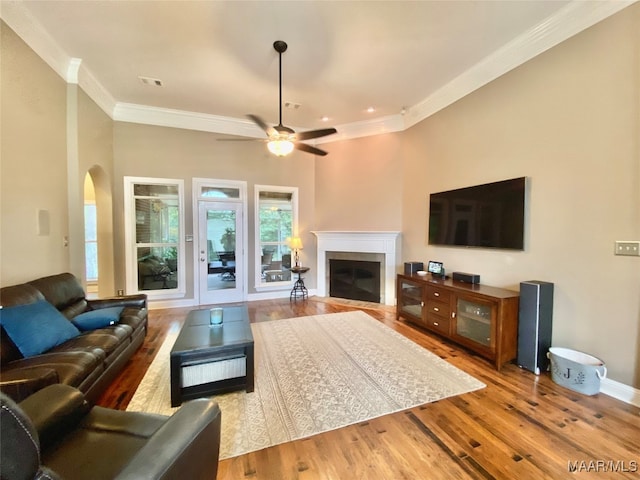 living room featuring crown molding, a tile fireplace, and hardwood / wood-style floors