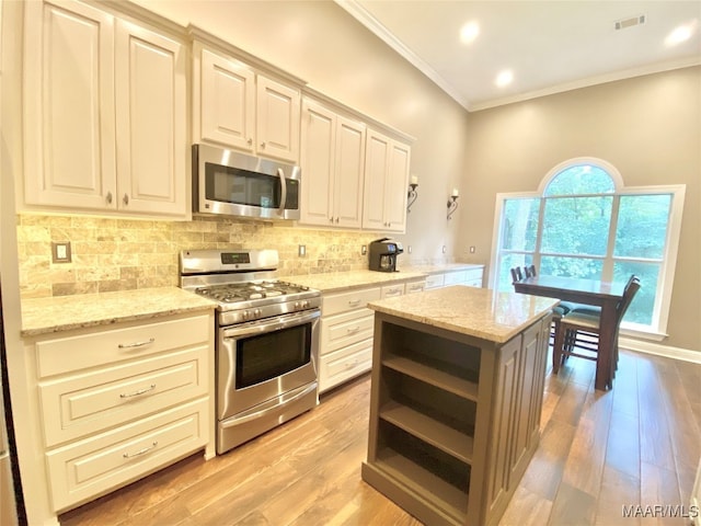 kitchen featuring light stone countertops, light hardwood / wood-style floors, crown molding, and appliances with stainless steel finishes