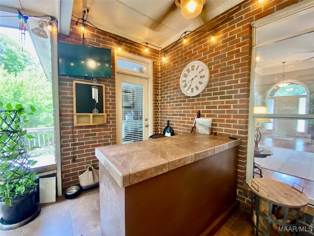 kitchen featuring brick wall and ornamental molding