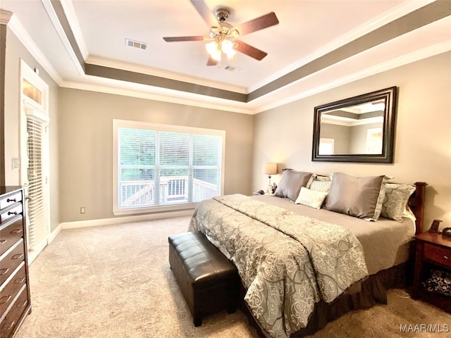 bedroom featuring ornamental molding, a raised ceiling, light carpet, and ceiling fan