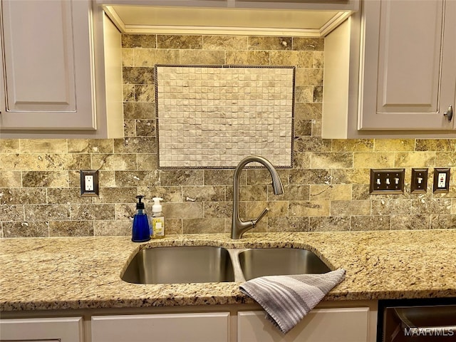 kitchen featuring sink, light stone counters, and tasteful backsplash