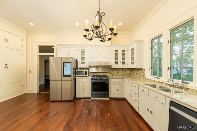 kitchen with pendant lighting, appliances with stainless steel finishes, dark wood-type flooring, and light stone countertops