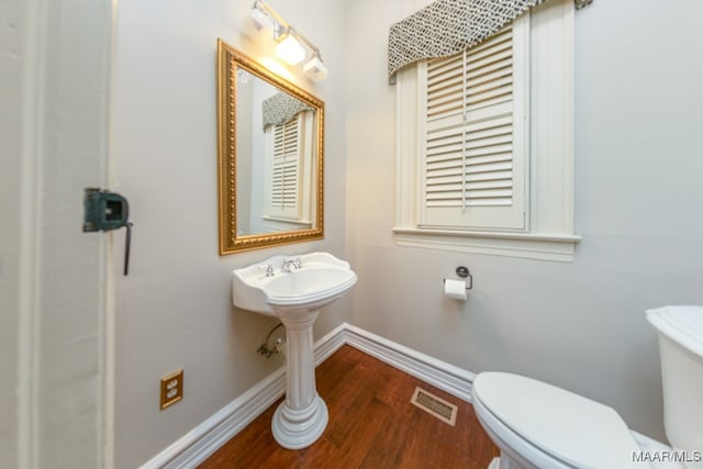 bathroom with wood-type flooring and toilet